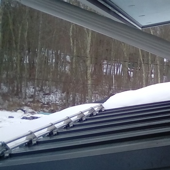 AceClamp metal roof snow guards securing heavy snow loads on a residential roof.