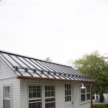 Close-up of powder-coated metal roof snow stops ready to prevent the snow avalanche.