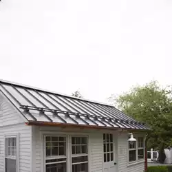 Close-up of powder-coated metal roof snow stops ready to prevent the snow avalanche.